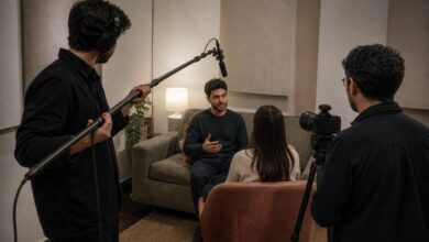 Operador de pértiga coloca un micrófono de cañón sobre una entrevista sin entrar en el encuadre